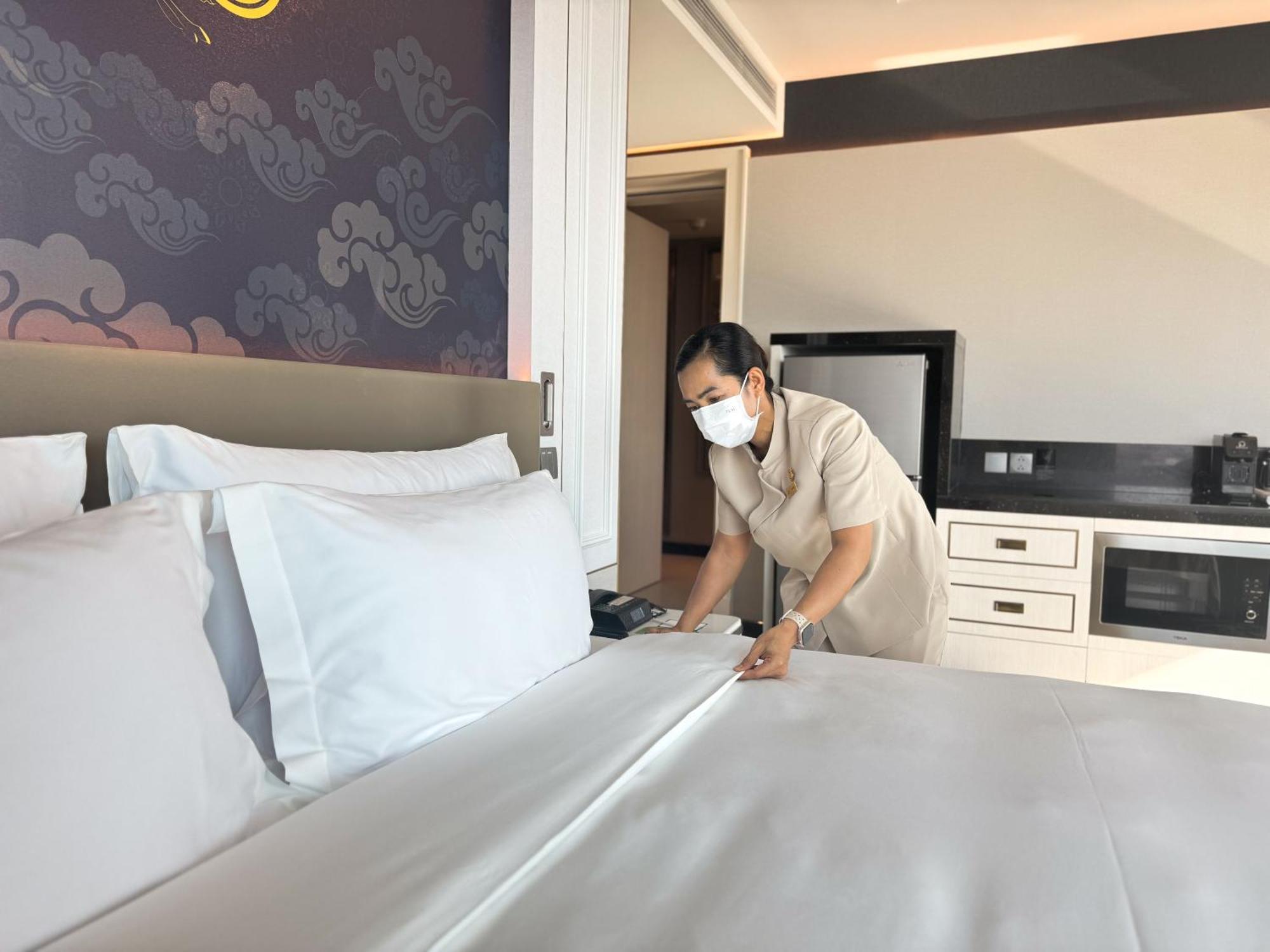 Hotel Grande Centre Point Surawong Bangkok Esterno foto A housekeeper making a bed at a hotel